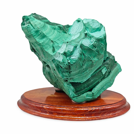 Malachite mineral specimen on a wooden base against a white background