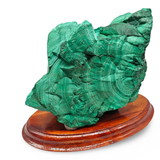 Natural malachite stone specimen on a wooden display base